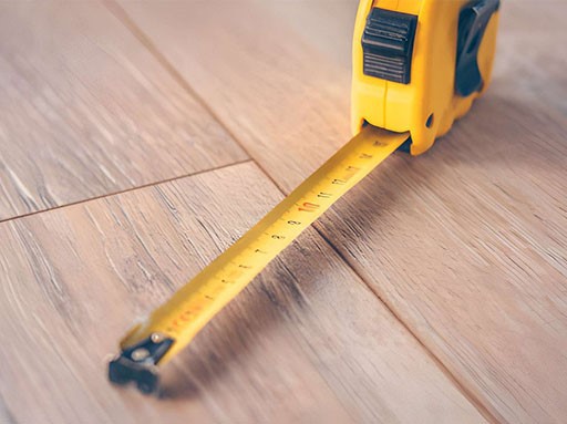Construction tape measure on a wooden floor Construction tape measure on a wooden floor